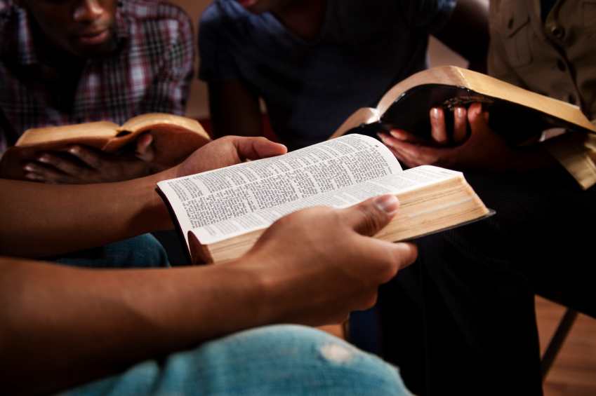 Hand resting on an open Bible during study